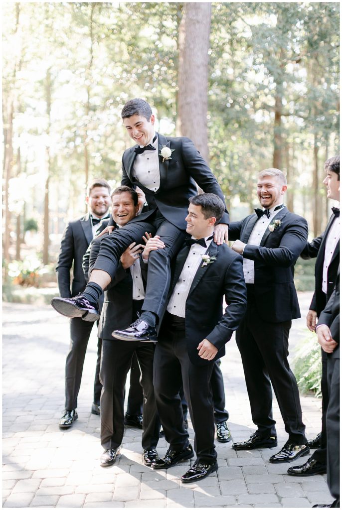 A groom being hoisted into the air. 
