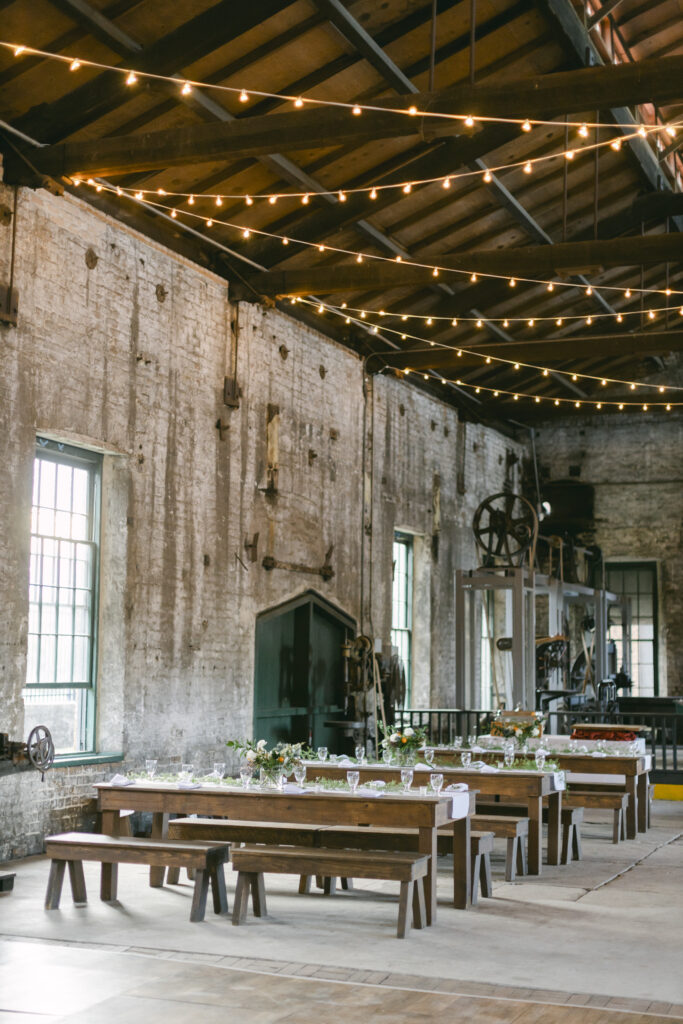 Wedding tables and glasses set up inside of a 19th-century railroad museum.