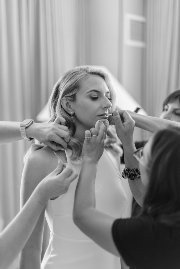 A bride being touched up by make-up artists.