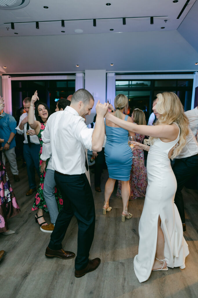A bride and groom dance surrounded by people at the Riggs Hotel DC.