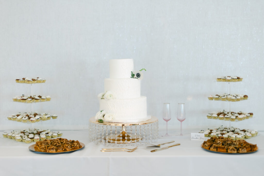 A full table spread with a wedding cake and treats. 