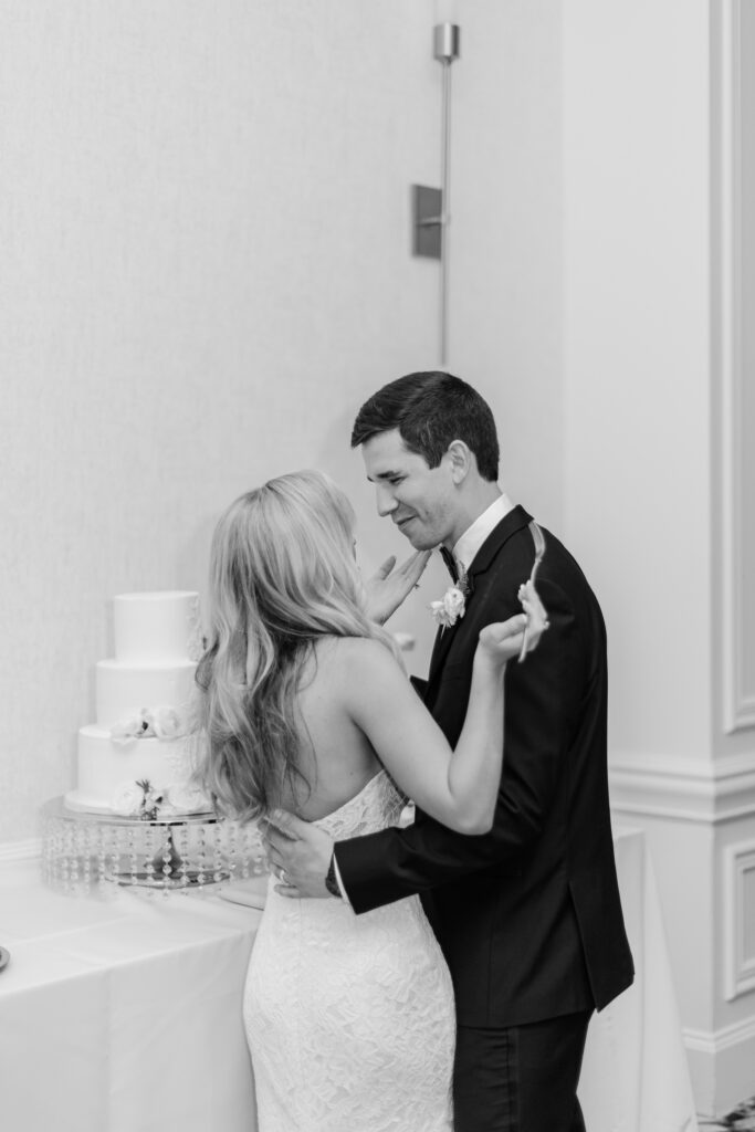 A bride and groom feeding cake to one another. 