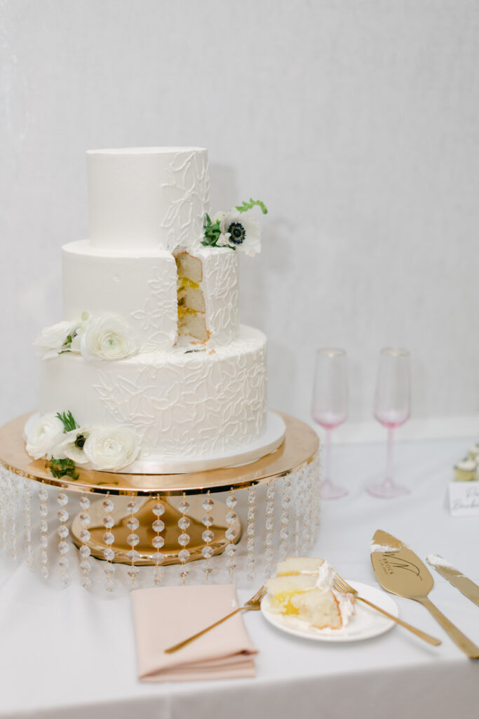 A wedding cake with a slice cut out of it. 