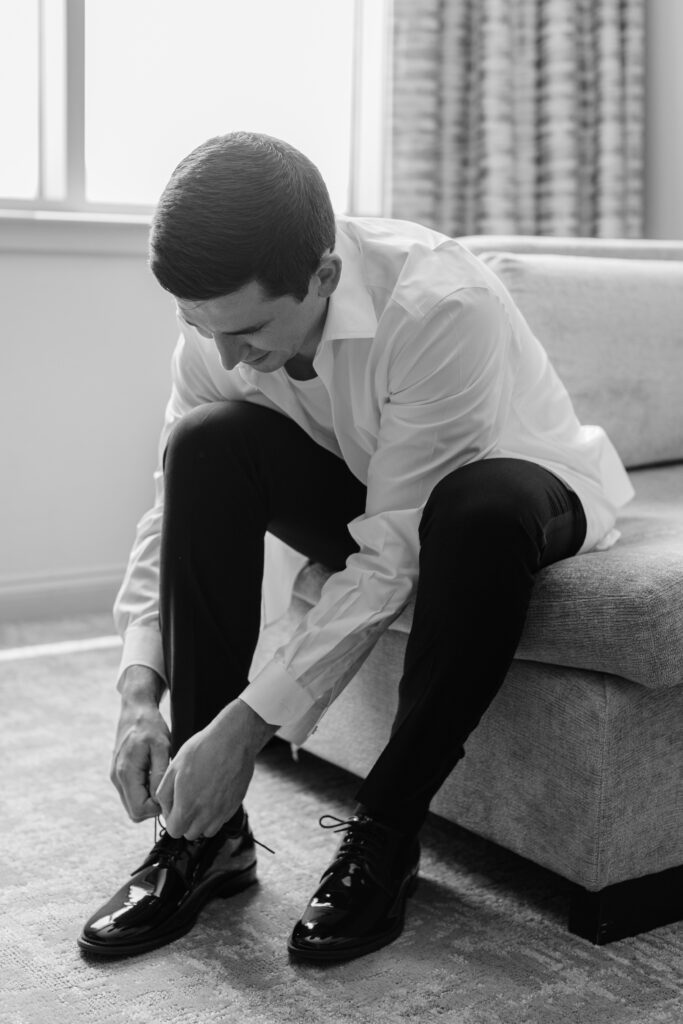 A groom tying his shoes. 