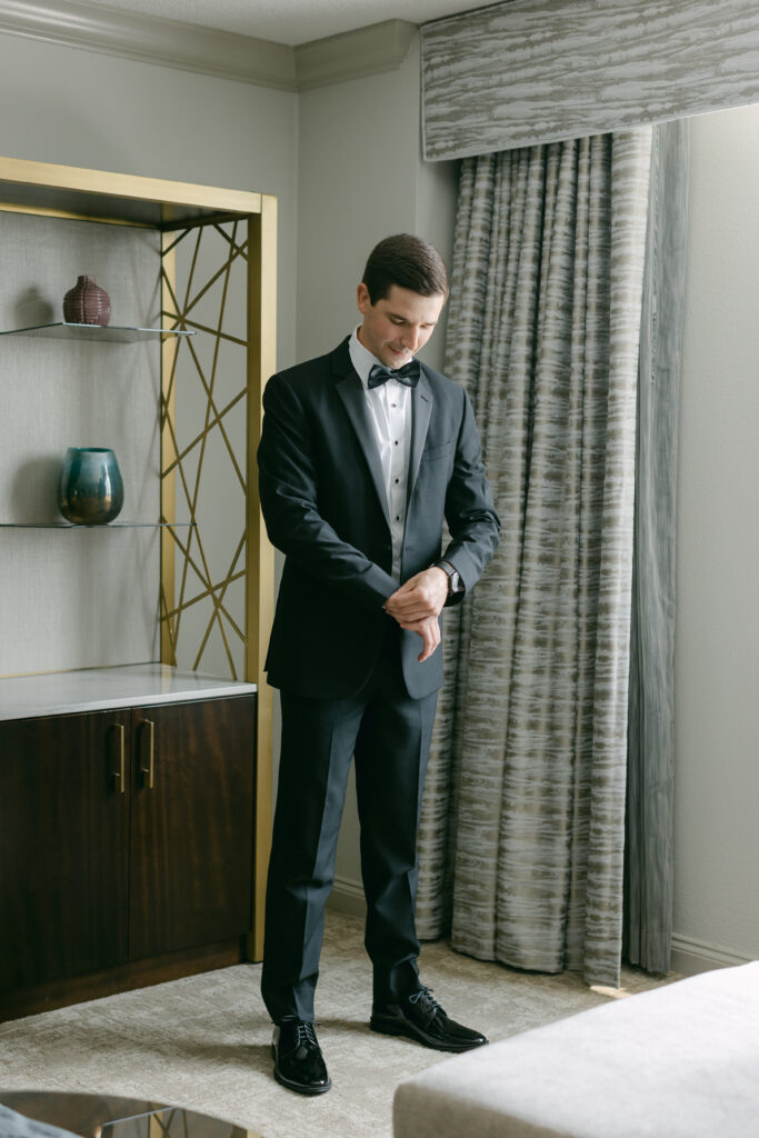 A groom getting dressed. 