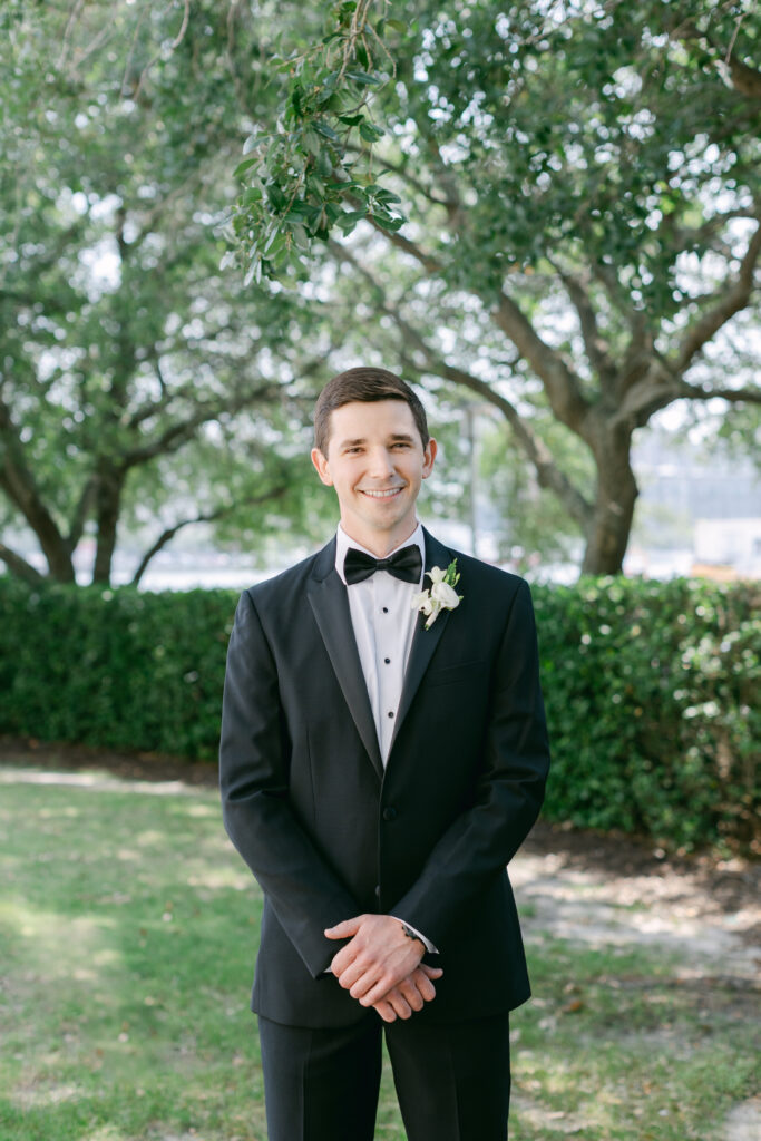 A groom smiling while he waits for his first look. 