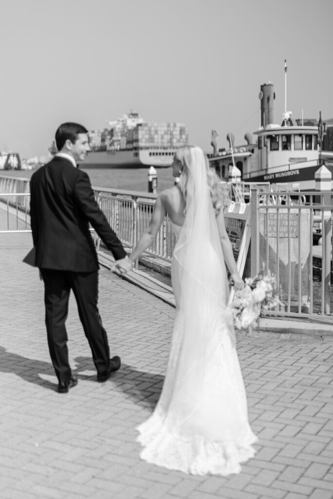 A bride and groom walk along the docks at the Westin Savannah. 