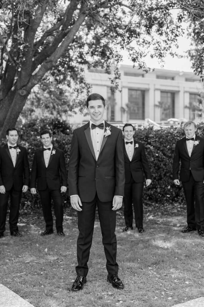 A groom standing in front of his groomsmen. 