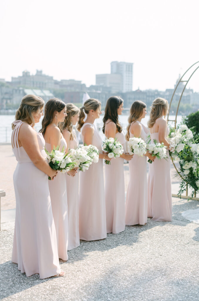 Bridesmaids standing at the alter holding flowers. 