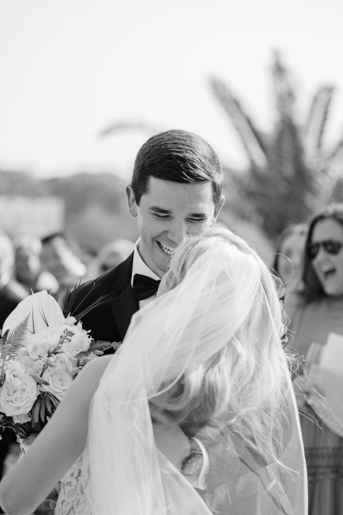 A groom laughs with joy with his bride. 