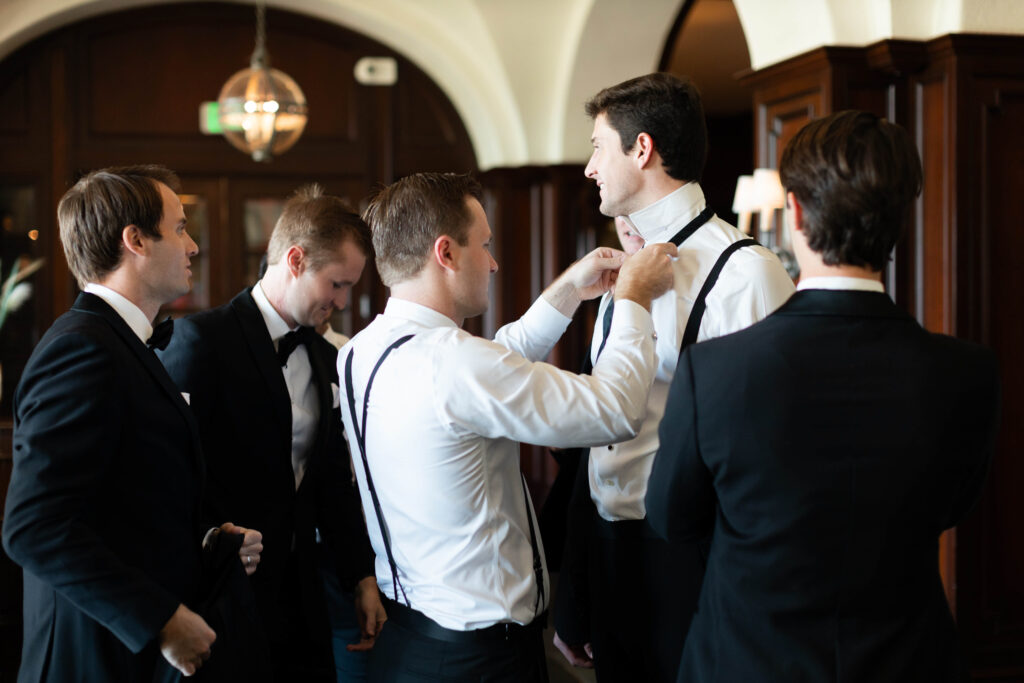 A groom fixes his best man's tie. 