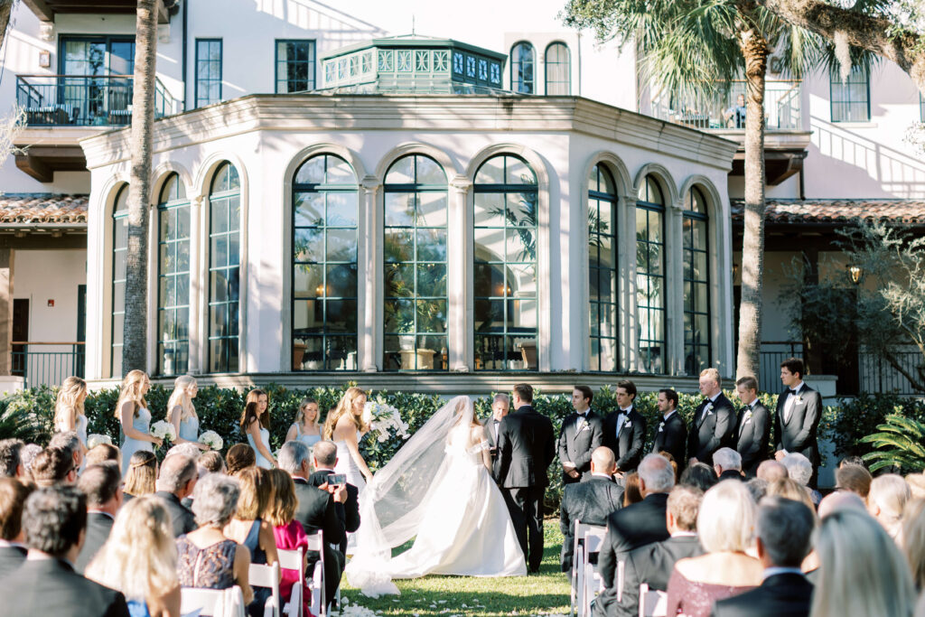 A bride and groom stand on the lawn of the Cloister at Sea Island and prepare to say "I Do".