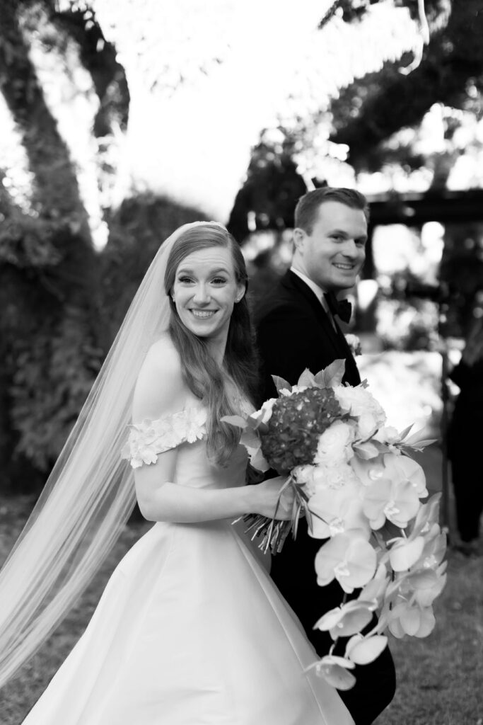 A bride smiles with her new husband as she walks back down the aisle. 