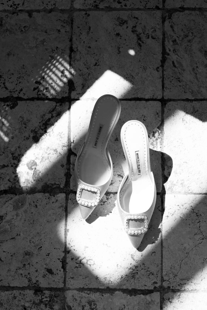 A pair of Manolo Blahnik heels sitting on stone tile.