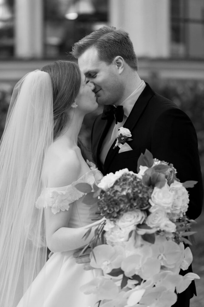 A bride and groom kiss. 