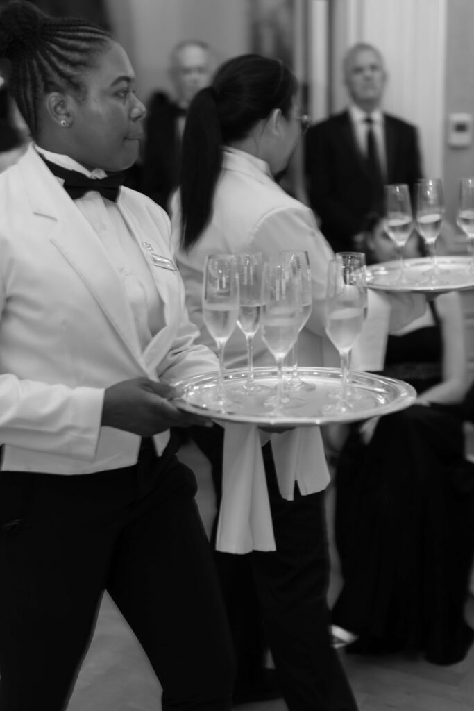 A server holds glasses of champagne. 