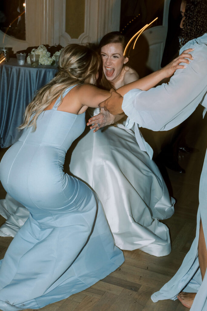 A bride dances and screams in the face of her bridesmaid. 