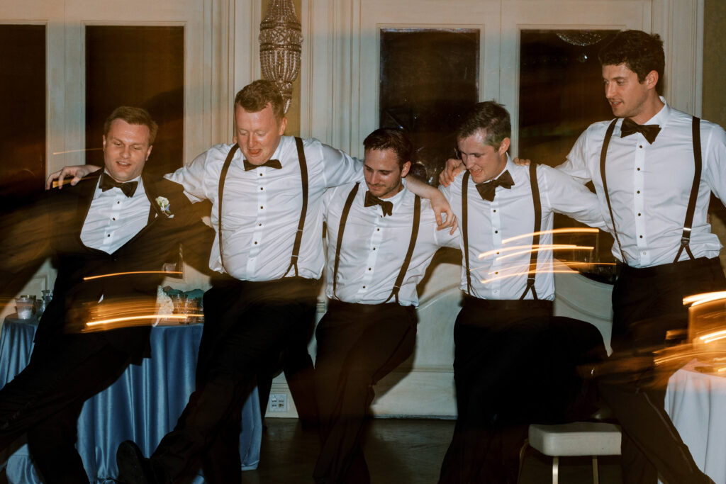 A groom and his best men all perform a ceremonial dance. 
