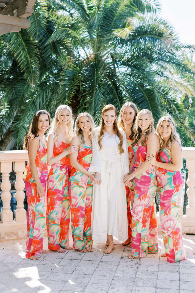 A bride and her bridesmaids standing on the Banks Parlor balcony.