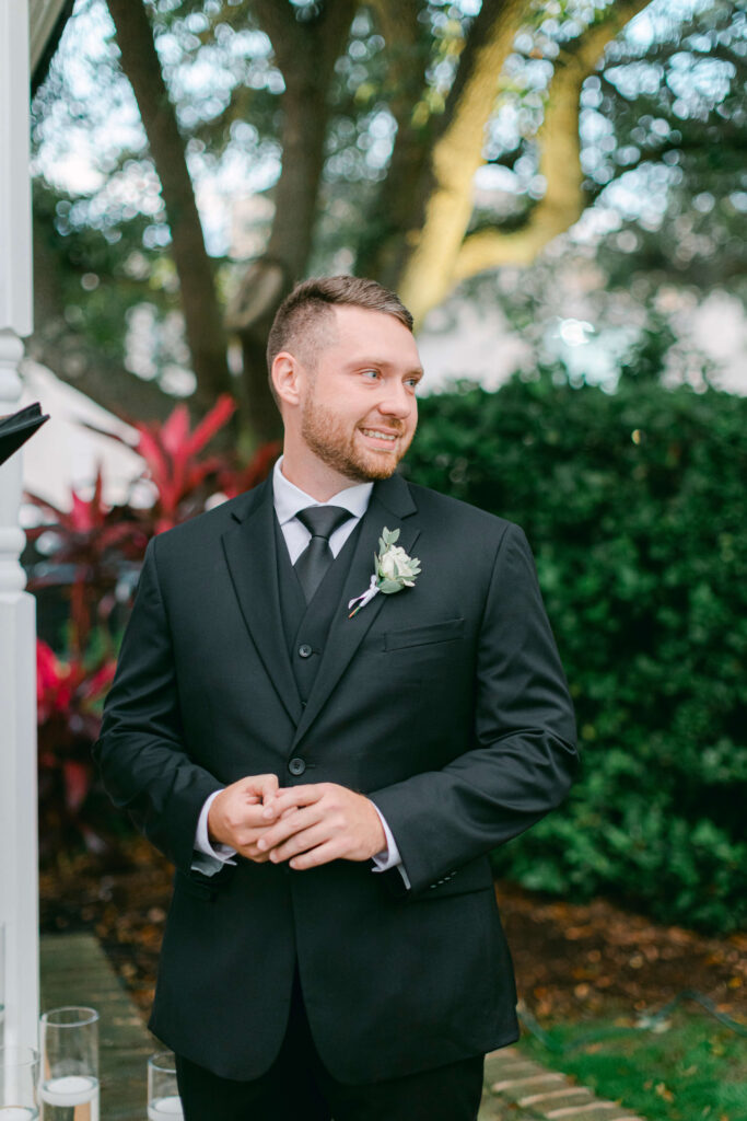 A groom smiles as his bride walks down the aisle. 