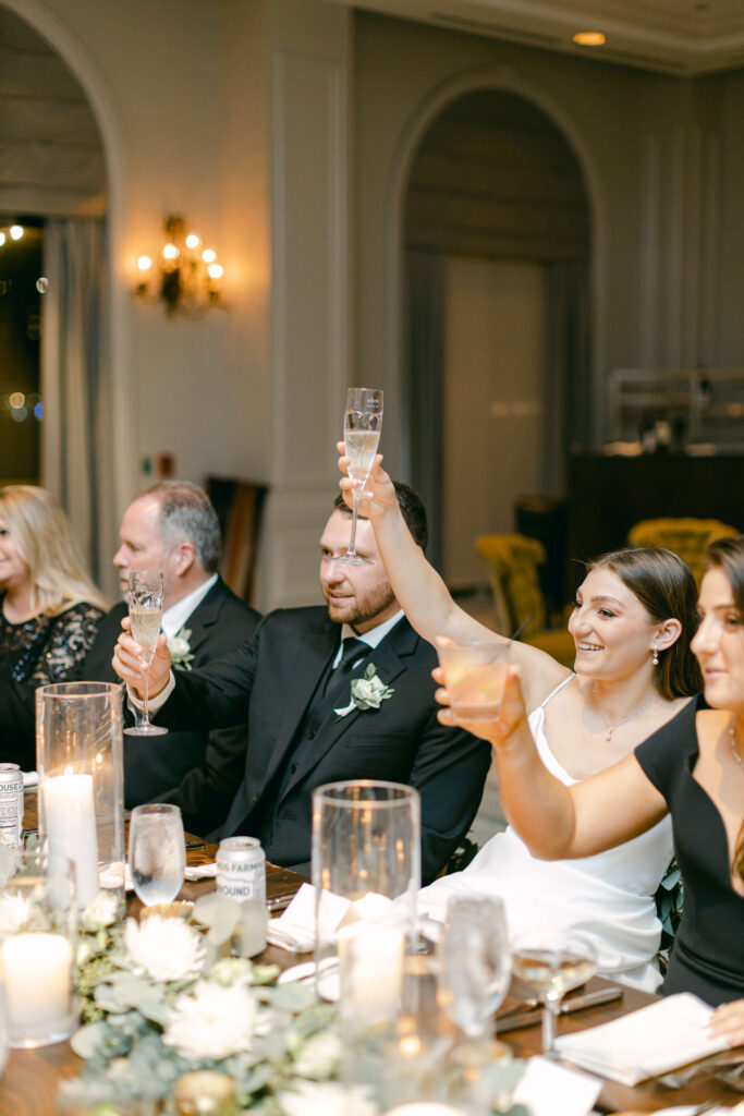 A bride raises her glass for a toast. 